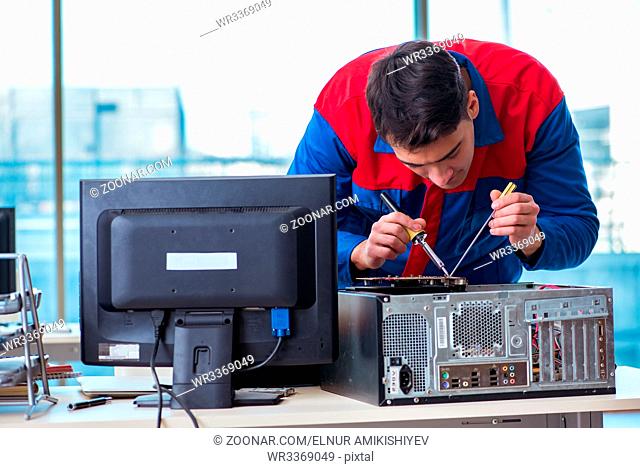 Computer technician repairing broken computer in workshop