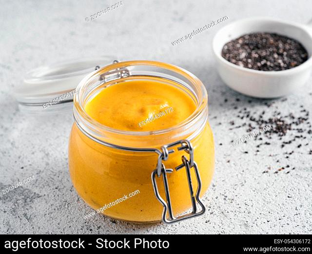 Creamy Cheddar sauce with chia seeds on gray background.Ideas and recipe for healthy diet or vegan food.Homemade Chia Cheeze Sauce for snacks, tacos, nachos