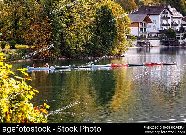 10 October 2023, Bavaria, Kochel Am See: Two people pull several other kayaks across the Kochelsee with one kayak. Photo: Matthias Balk/dpa