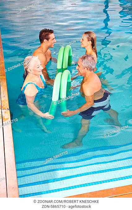 Gruppe macht Rückentraining durch Hydrotherapie mit Schwimmnudel im Pool