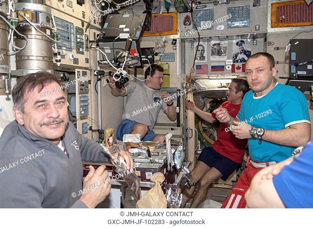 Expedition 35 crew members enjoy a meal in the Zvezda service module aboard the Earth-orbiting International Space Station on April 2