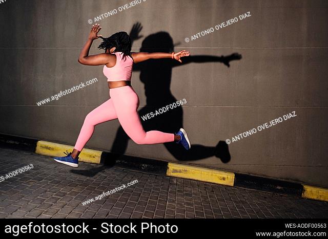 Plus size young woman jumping over road