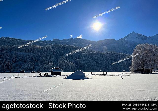 03 December 2023, Bavaria, Garmisch-Partenkirchen: The sun shines under a blue sky over the snow-covered landscape in Upper Bavaria