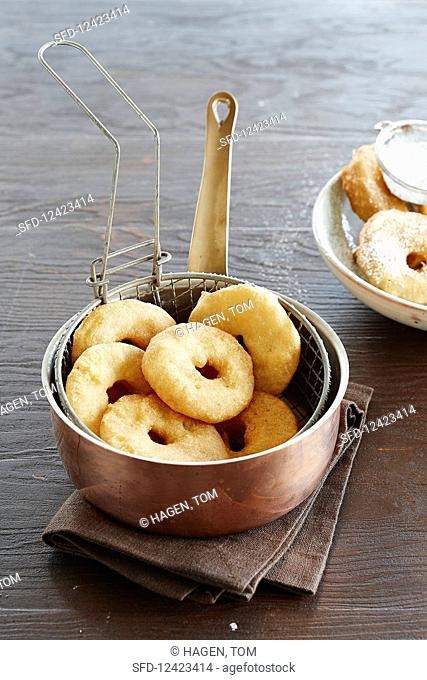 Apple beignets in a frying basket