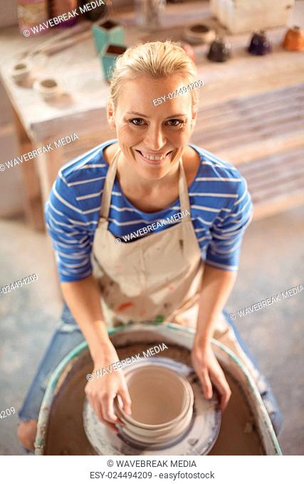 Beautiful female potter making pot