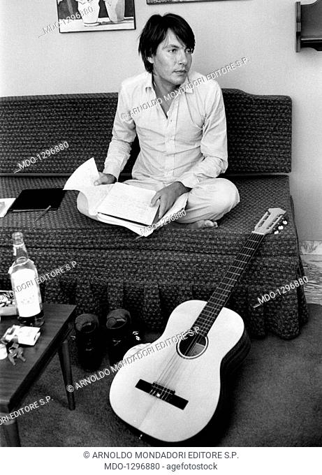 Fabrizio De André writing songs. Italian singer and songwriter Fabrizio De André sitting on a coach and composing some songs. Rome, 1971