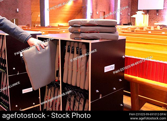 PRODUCTION - 24 October 2023, Hesse, Kassel: A heating pad is taken out of a charging station at Holy Trinity Church. (to dpa: ""Churches call on congregations...