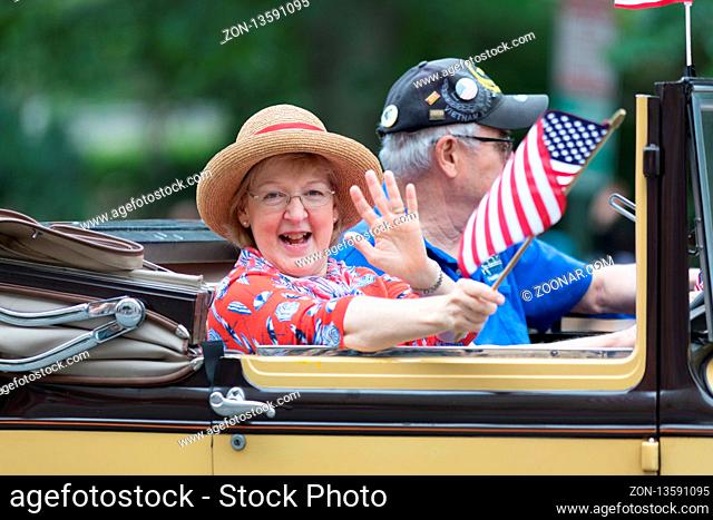 Washington, D.C., USA - May 28, 2018: The National Memorial Day Parade, Pople Waving american flags riding on Ford Model A classic cars, down contitution avenue
