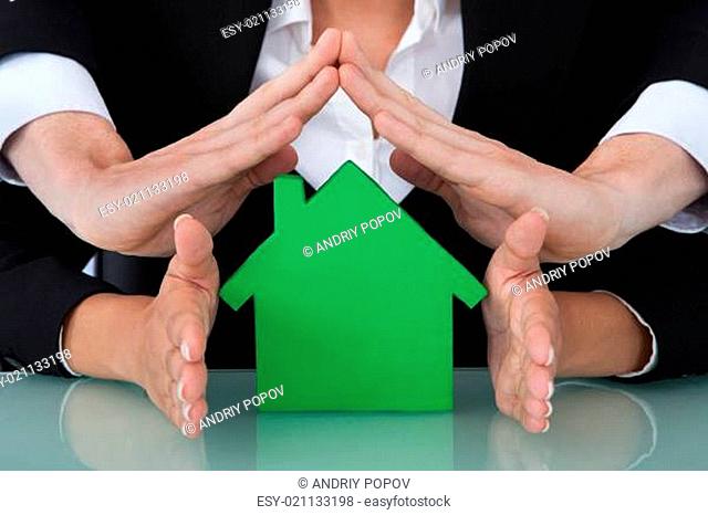 Business People Sheltering House Model In Office