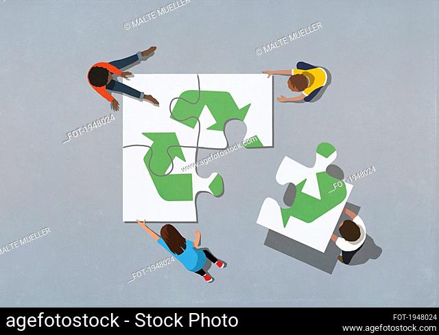 Team finishing recycling symbol jigsaw puzzle with missing piece