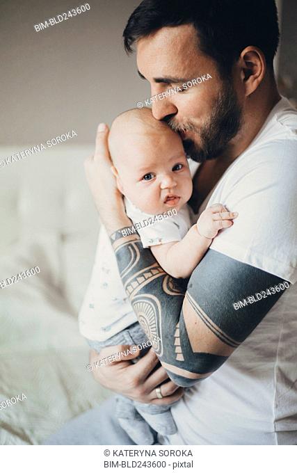 Caucasian father with tattoos on arms kissing baby son, Stock Photo,  Picture And Royalty Free Image. Pic. BIM-BLD243600 | agefotostock