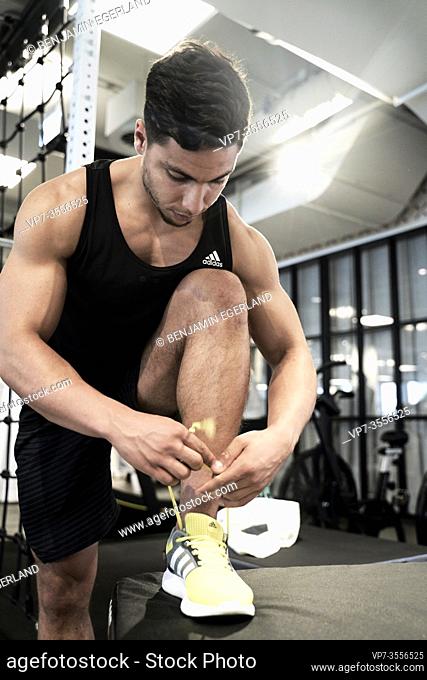 Man in gym tying up shoelaces