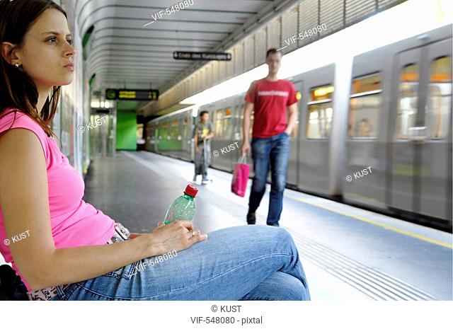 Frau wartet am Bahnhof auf den Zug. - Austria, 25/07/2007