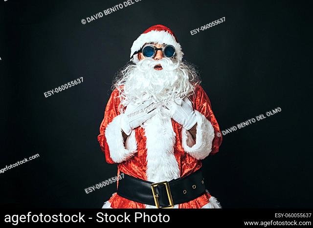 Man dressed as Santa Claus wearing Victorian style welder goggles, on black background. Christmas concept, Santa Claus, gifts, celebration