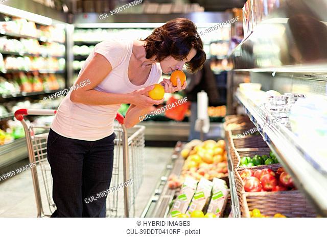 Woman smelling fruit at grocery store