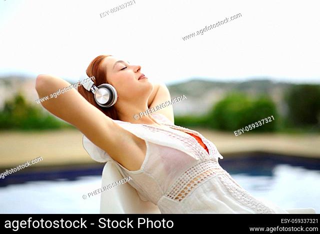 Relaxed woman listening to music resting in a pool