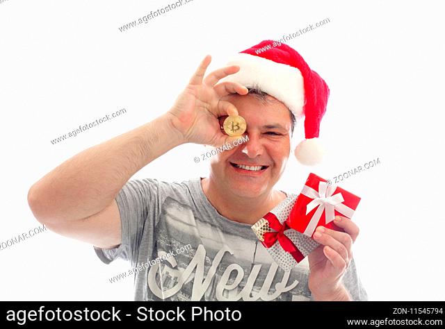 Sydney, Australia - December 17, 2017; Man holding a Bitcoin - digital crypto currency and some small presents at Christmas time