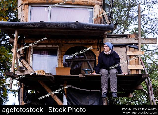 PRODUCTION - 20 October 2022, North Rhine-Westphalia, Lützerath: Environmental activist Mara Sauer sits on the porch of a tree house in the protest camp