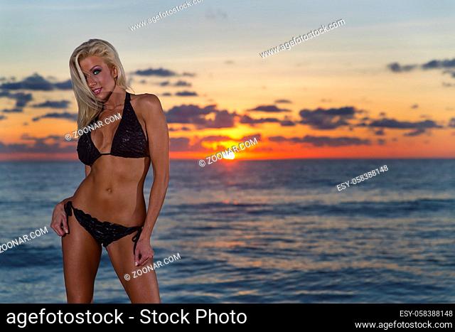 A bikini model posing at sunrise