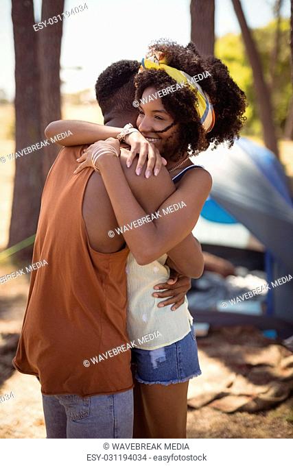 Side view of couple embracing while standing against tent