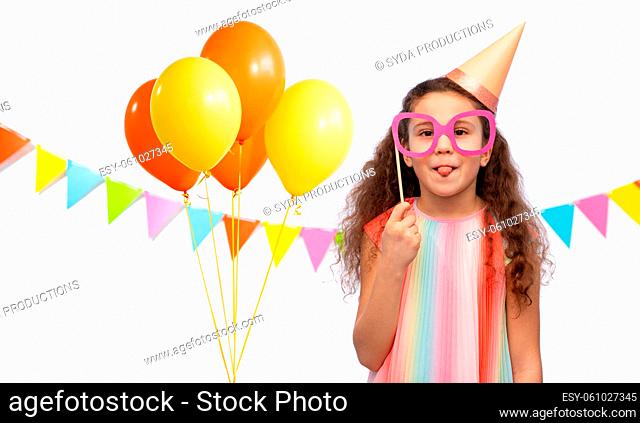 little girl in birthday party hat with glasses
