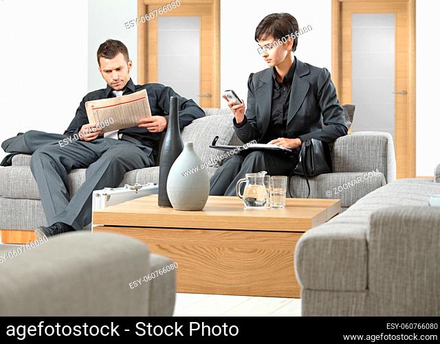 Business people sitting on sofa at office anteroom waiting