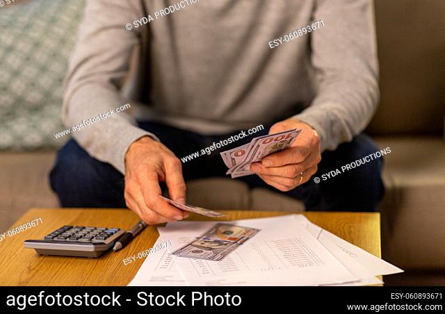 senior man counting money at home