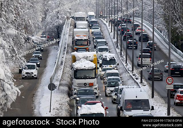 04 December 2023, Bavaria, Munich: Numerous cars drive across the central ring road during rush hour. Snow and ice continue to cause chaos on the roads in the...