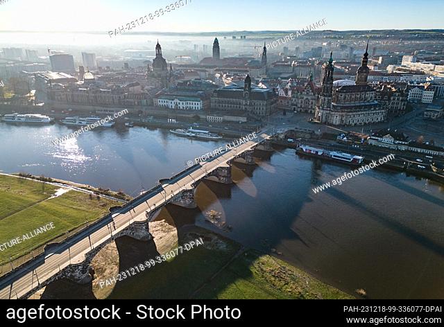 18 December 2023, Saxony, Dresden: The sun shines in the morning on the old town on the Elbe with the dome of the Kunstakedmie with the angel ""Fama"" (l-r)