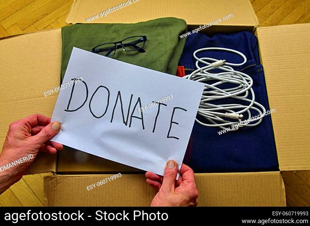 Donation concepts with hands of man holding text DONATE . Giving and sharing things with other people