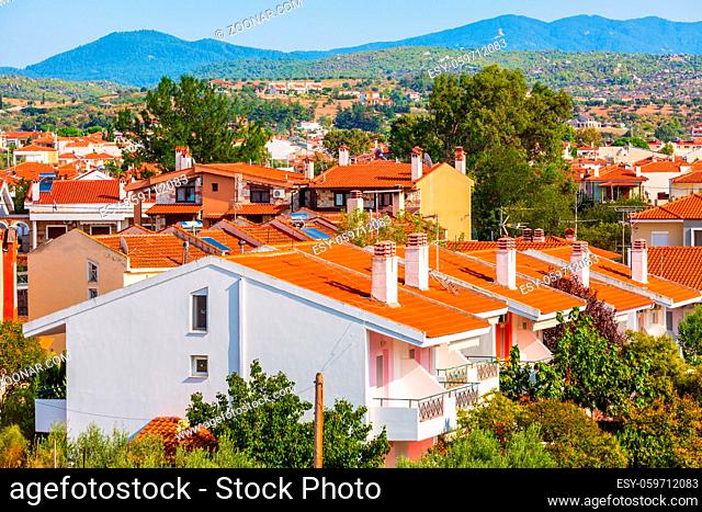 Nikiti, Sithonia, Chalkidiki Peninsula, Greece panorama with row of red roof houses, olive garden and mountains