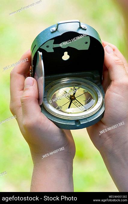 Germany, Bavaria, boy holding a compass in his hands, detail