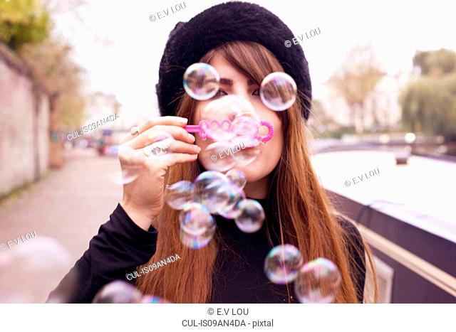 Portrait of woman blowing bubbles