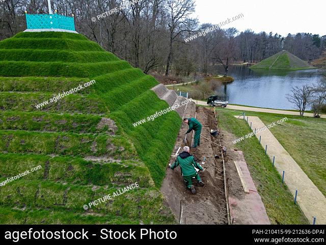 15 April 2021, Brandenburg, Branitz: Employees of the Fürst-Pückler-Museum Park and Branitz Castle Foundation working on the steps of the historic land pyramid...