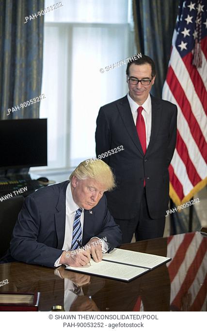 US President Donald J. Trump (L), with Secretary of Treasury Steven Mnuchin (R), signs a financial services Executive Order during a ceremony in the US Treasury...