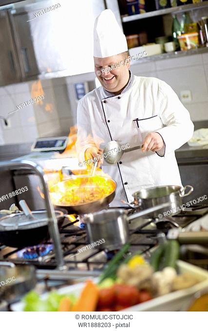Chef flambeing food in pan