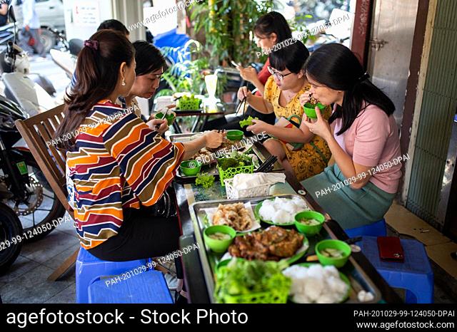 23 October 2020, Vietnam, Hanoi: Customers eat worm omelets, which are usually served with rice noodles, a sweet and sour fish sauce and a glass of iced tea
