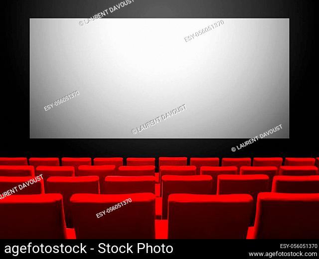 Cinema movie theatre with red velvet seats and a blank white screen. Copy space background