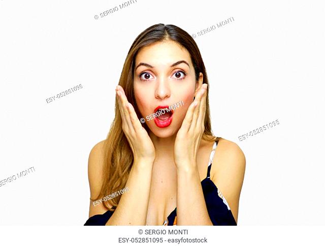 Surprised beautiful young woman in elegant dress holding face with hands shouting and looking at camera on white background