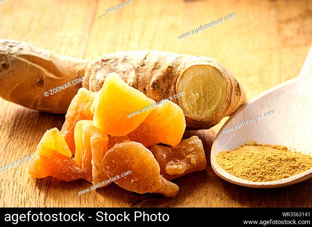 Three kinds of ginger - ground spice fresh and candied on rustic table. Healthy eating, home remedy for nausea upset stomach colds