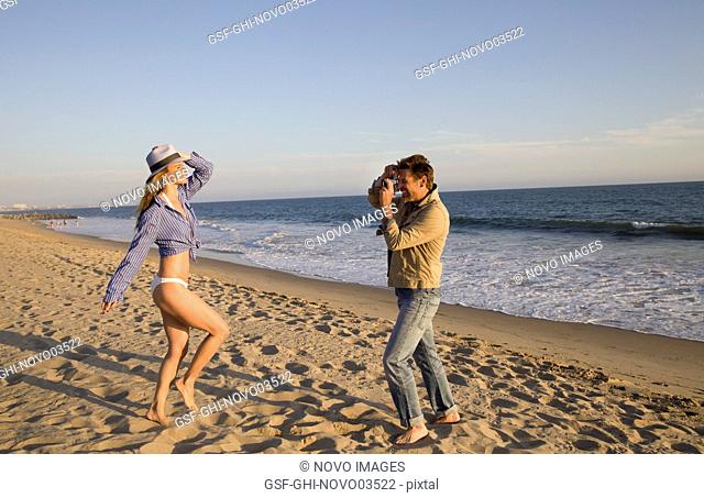 Man Taking Photo of Woman on Beach II