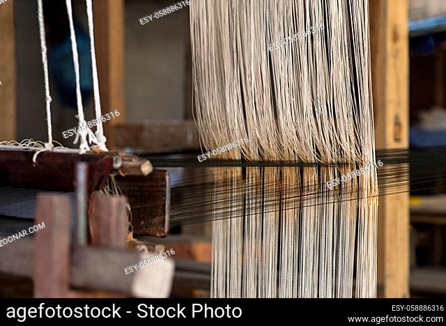 Weben an einem traditionellen Lao-Thai Webstuhl, Ban Phanom, Laos / Weaving on a traditional Lao-Thai style loom, Ban Phanom, Laos