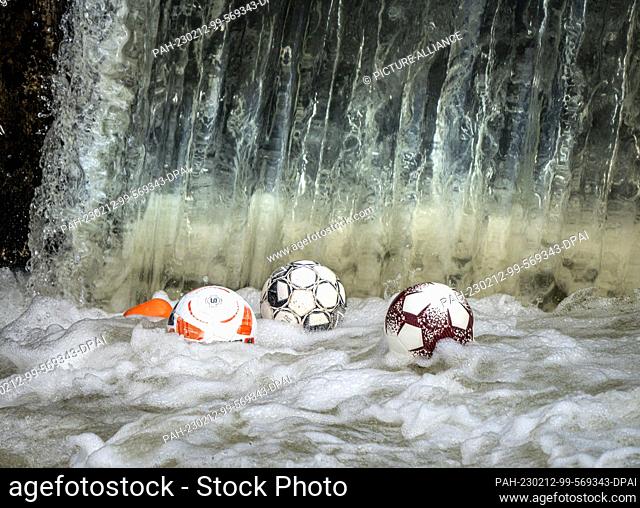12 February 2023, Hesse, Frankfurt/Main: Footballs dance on the water at a weir on the Nidda River, where they are caught in the water's undertow