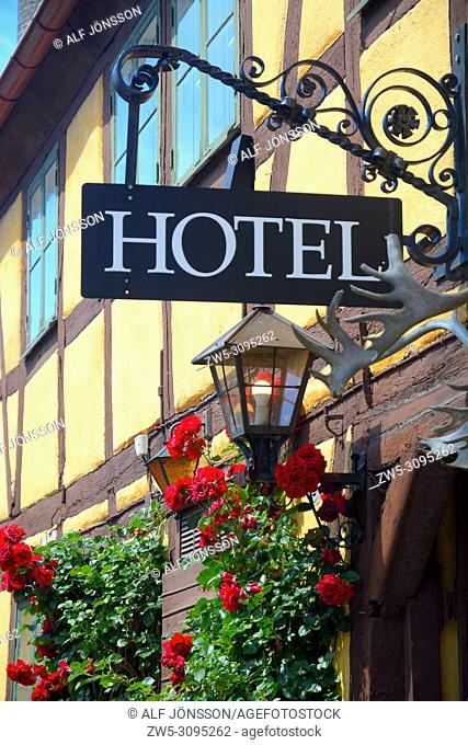 Hotel facade with roses, lamp and sign at an old house in Ystad, Scania, Sweden
