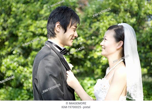 Bride and groom face to face smiling outdoors