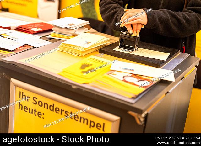 06 December 2022, Baden-Wuerttemberg, Freiburg: Sevilay Catakli, an employee of a postal service provider, cancels a letter with a special St