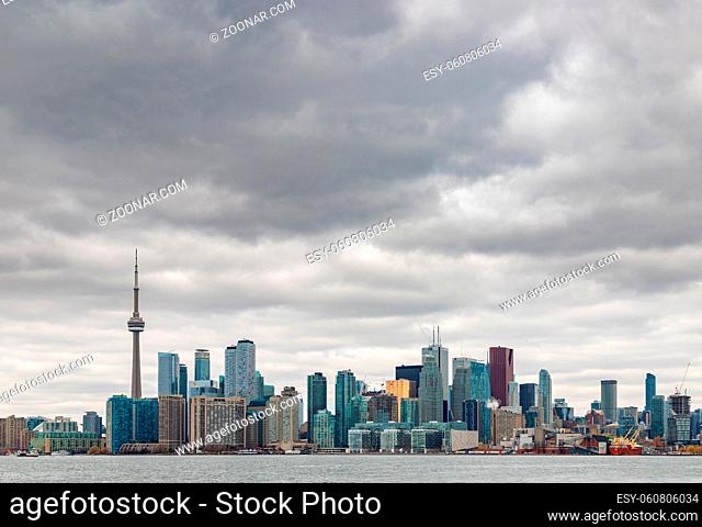 A picture of the Toronto Skyline on a cloudy day taken from the islands across