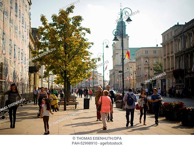 Pedestrians, local residents and tourists, walk on a busy street in the Nowe Miasto neighbourhood of Warsaw, Poland, 11 October 2014