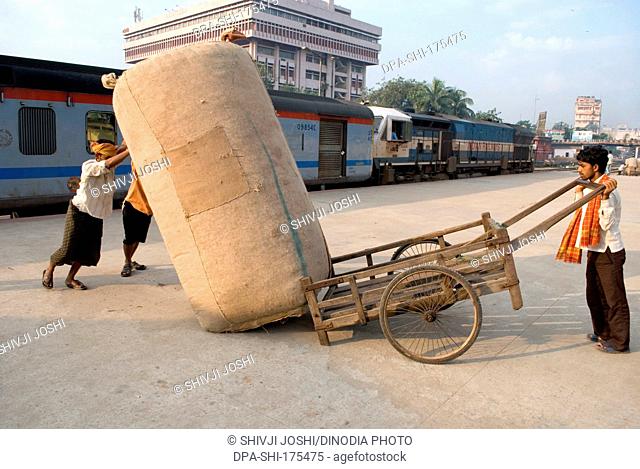 Labourers dragging luggage at railway platform ; Guwhati ; Assam ; India NOMR