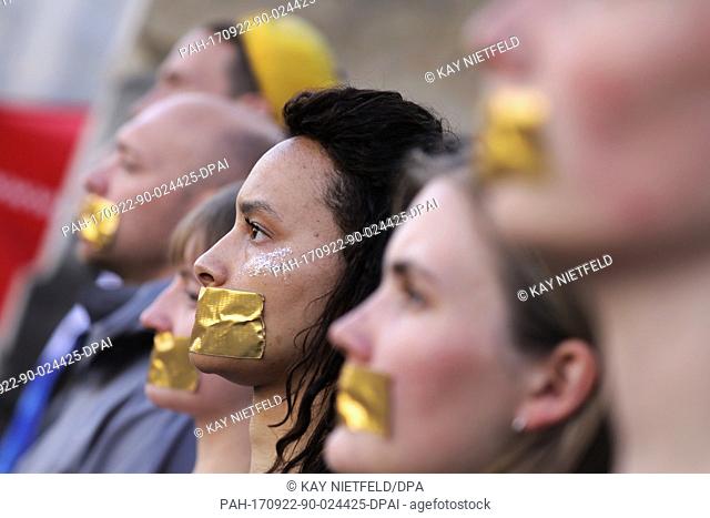 Students pasted a golden piece of paper in front of their mouths during a protest action for more democracy before a campaign event on the German federal...